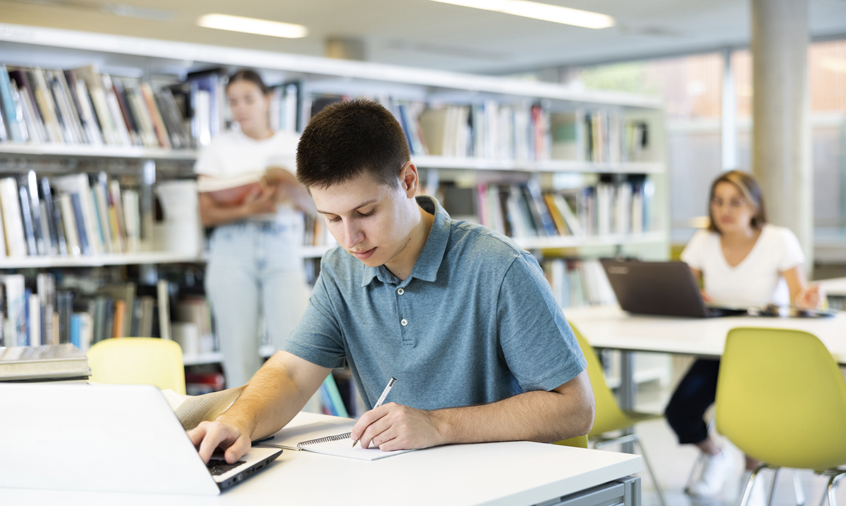 Étudiant travaillant dans une bibliothèque universitaire.
